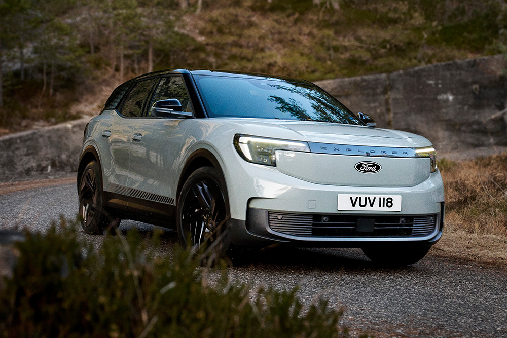 Elektrische Ford Explorer rijdend op een bochtige weg door de heuvels.