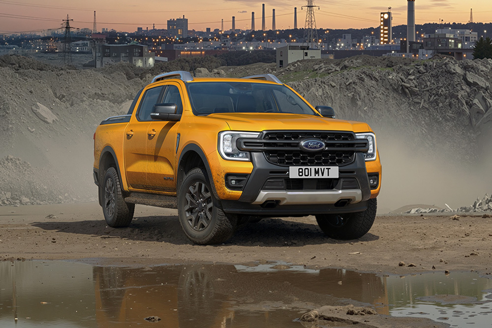 le Ford Ranger pick-up op een modderig bouwterrein bij zonsondergang.