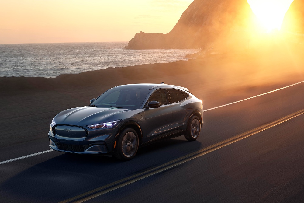 Ford Mach-E driving seaside road in sun set