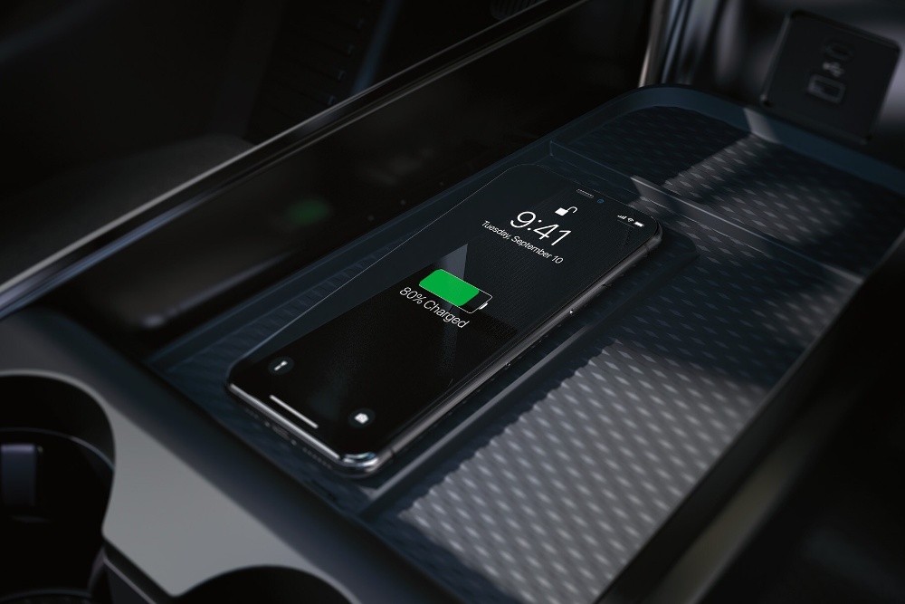 Een close-up van het draadloze oplaadstation in de middenconsole, waarop een iPhone wordt opgeladen.