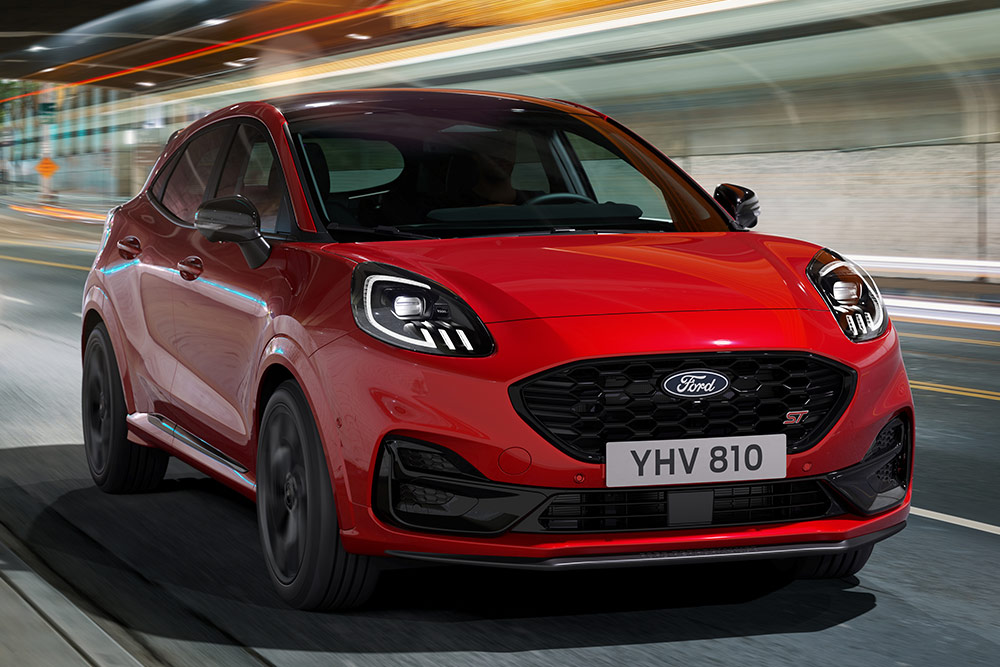 Vooraanzicht tijdens het rijden van een rode Ford Puma ST.