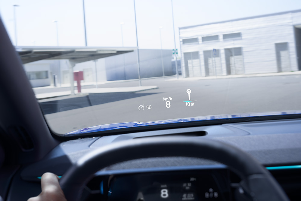 Het interieur van een Ford, met een close-up van het stuur en uitzicht door de voorruit.