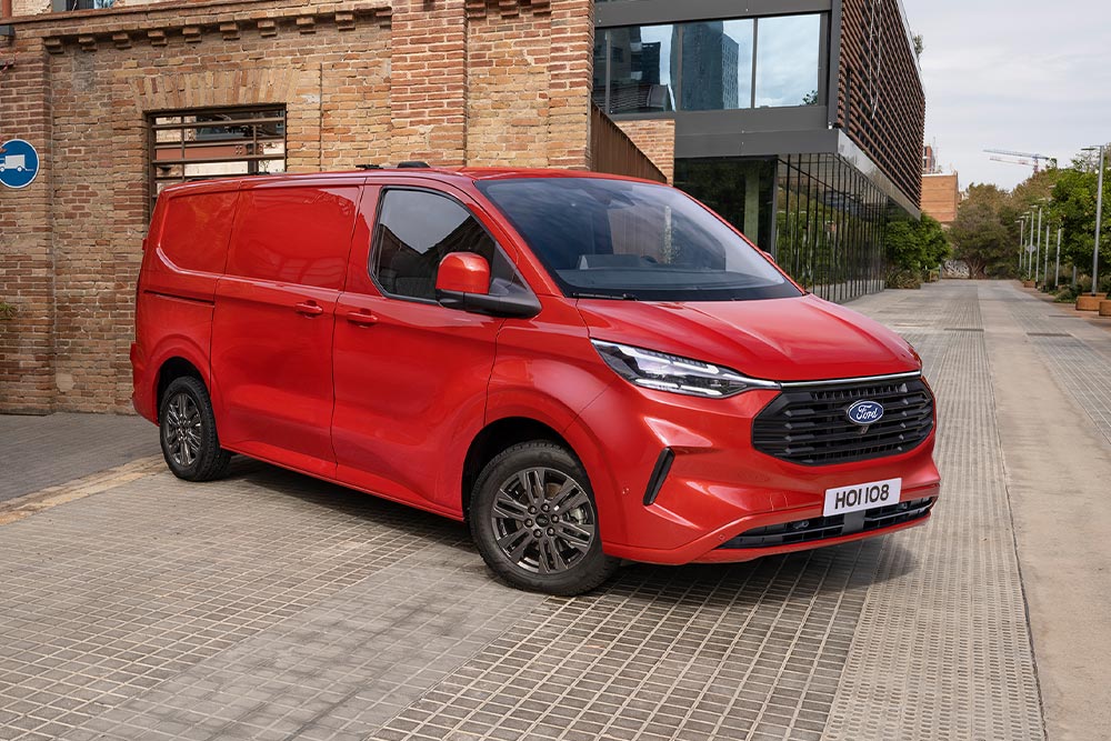 Een rode Ford Transit Custom bestelwagen geparkeerd in een stadsstraat.