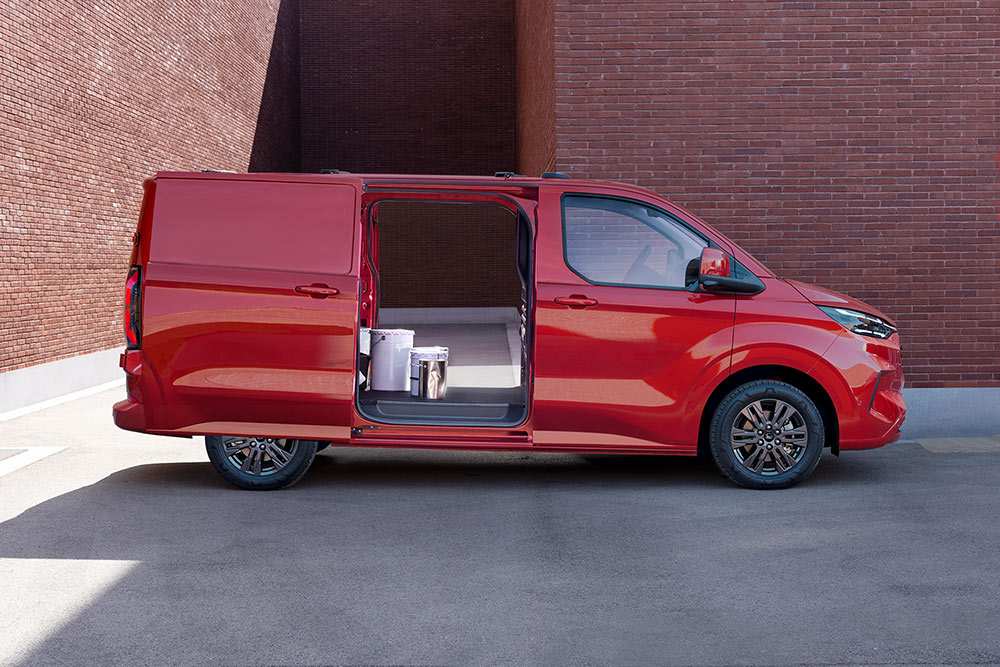 Een rode Ford Transit Custom bestelwagen met open zijschuifdeuren, die het interieur toont.
