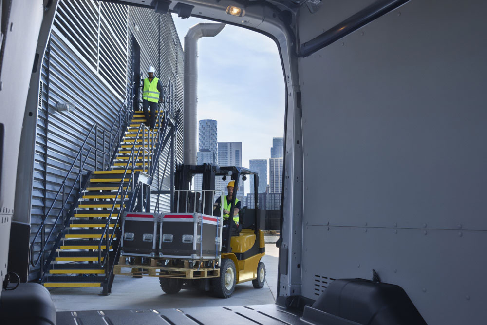  Inside view of a Ford Transit van with a forklift loading cargo.