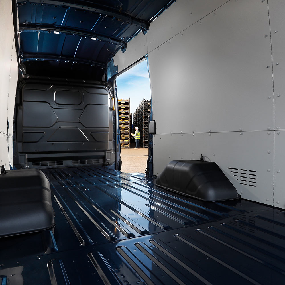 Het interieur van een Ford E-Transit elektrische bestelwagen met een lege laadruimte.