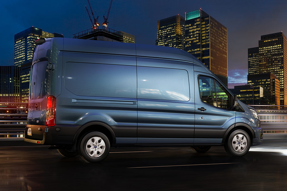 Een Ford Transit-bestelwagen die 's nachts door de stad rijdt.