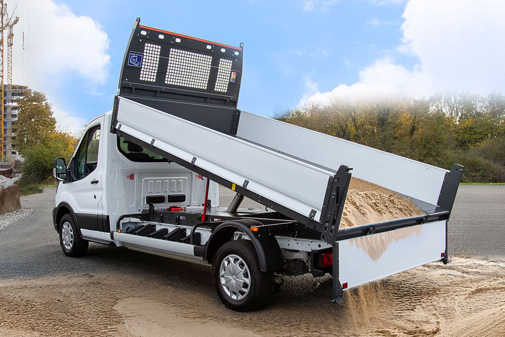 Witte Ford Pro Chassis Cab met verhoogde laadbak geparkeerd op een bouwplaats.