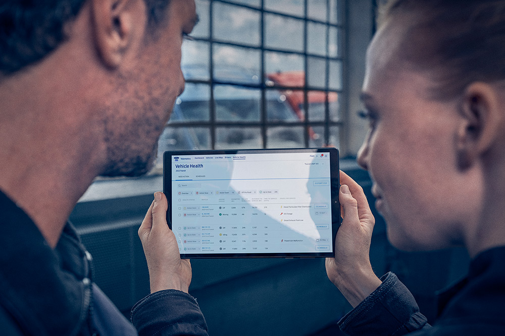 Wagenparkbeheerders bekijken de data van Ford Pro™ Telematics op een tablet.
