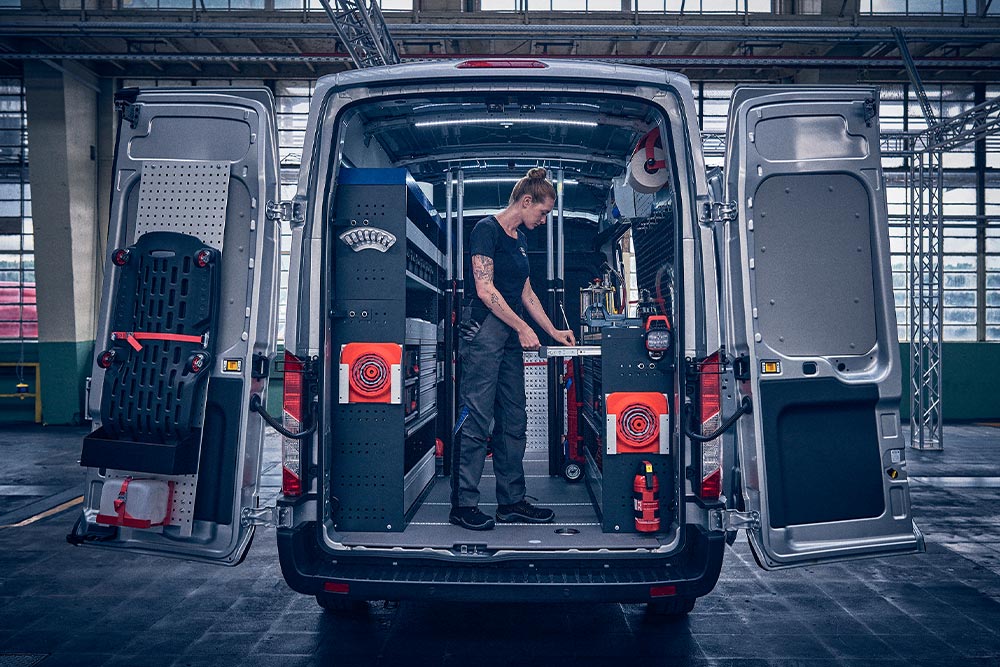 Technicus achterin een Ford bestelwagen, die gegevens op zijn laptop controleert.