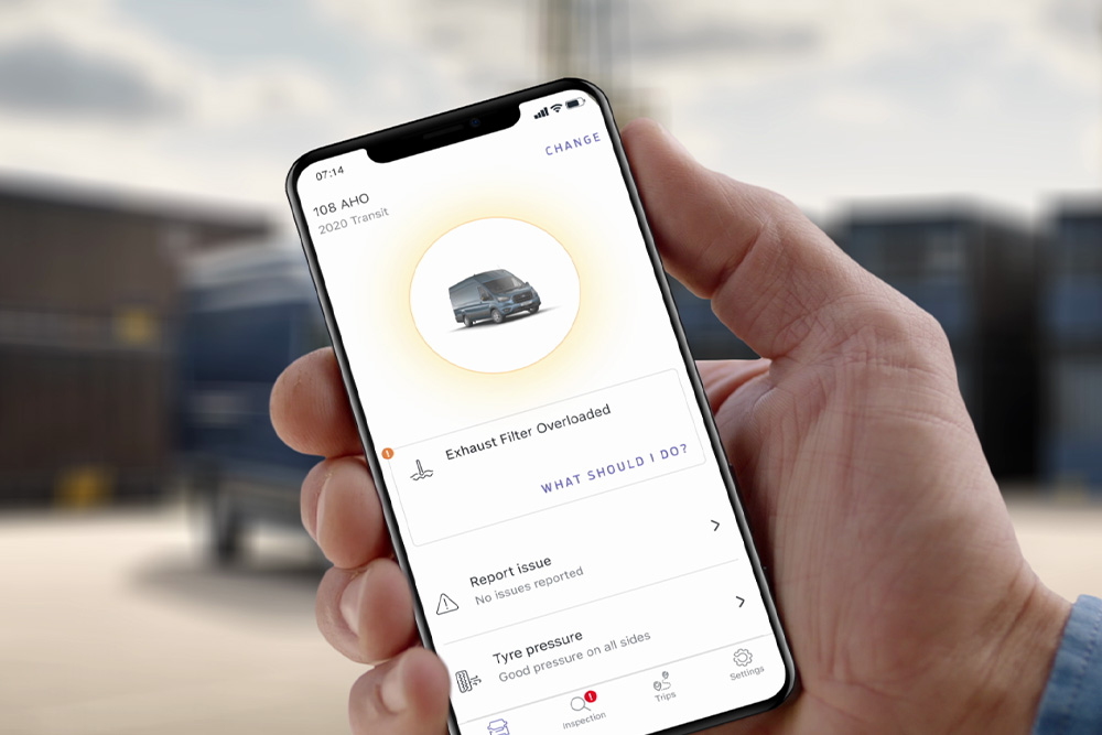Een hand houdt een mobiel apparaat vast, waarop de Ford Telematics Drive app wordt getoond.